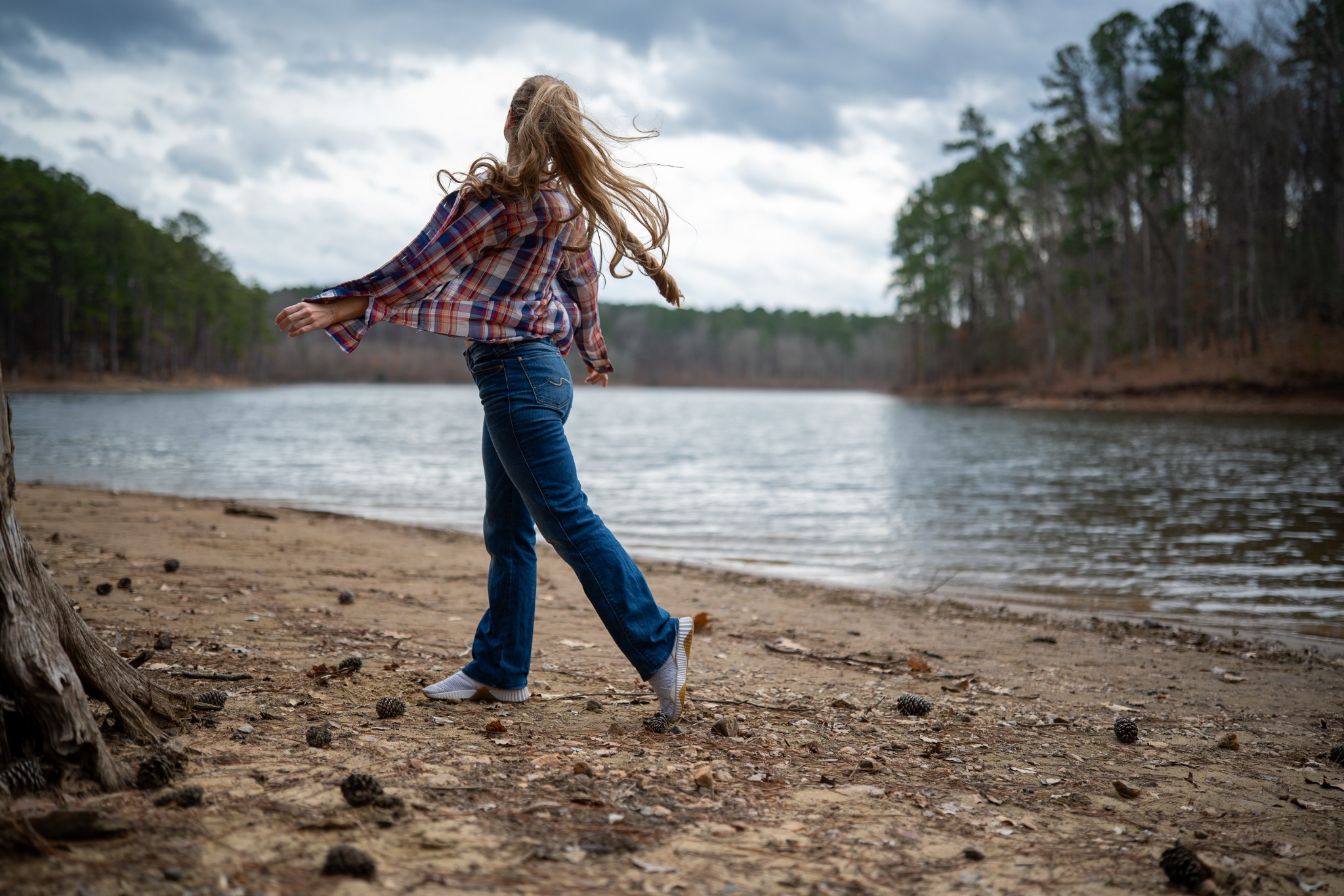 Candid lakeside portrait of a woman moving along the shore