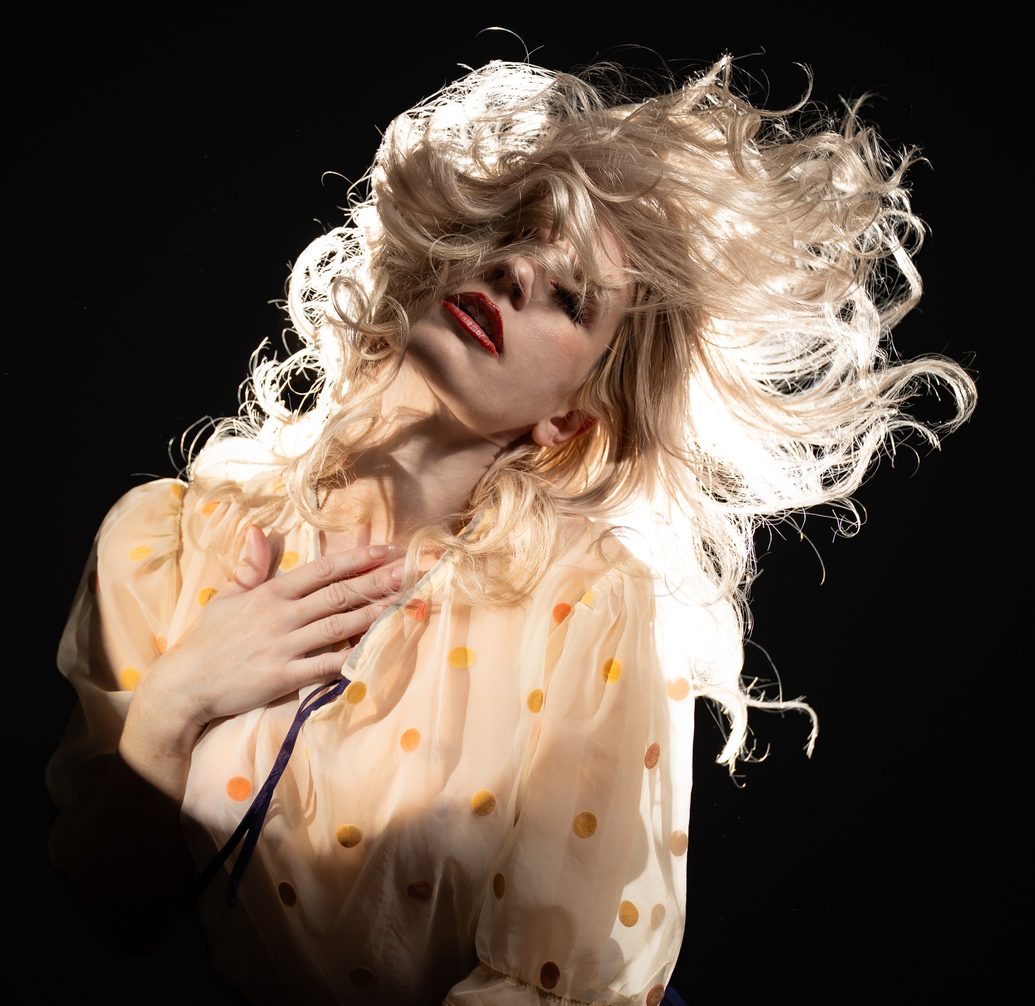 High-energy beauty portrait with windswept blonde hair